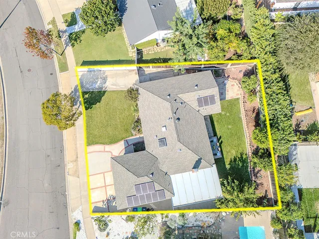 an aerial view of a house with a yard and swimming pool