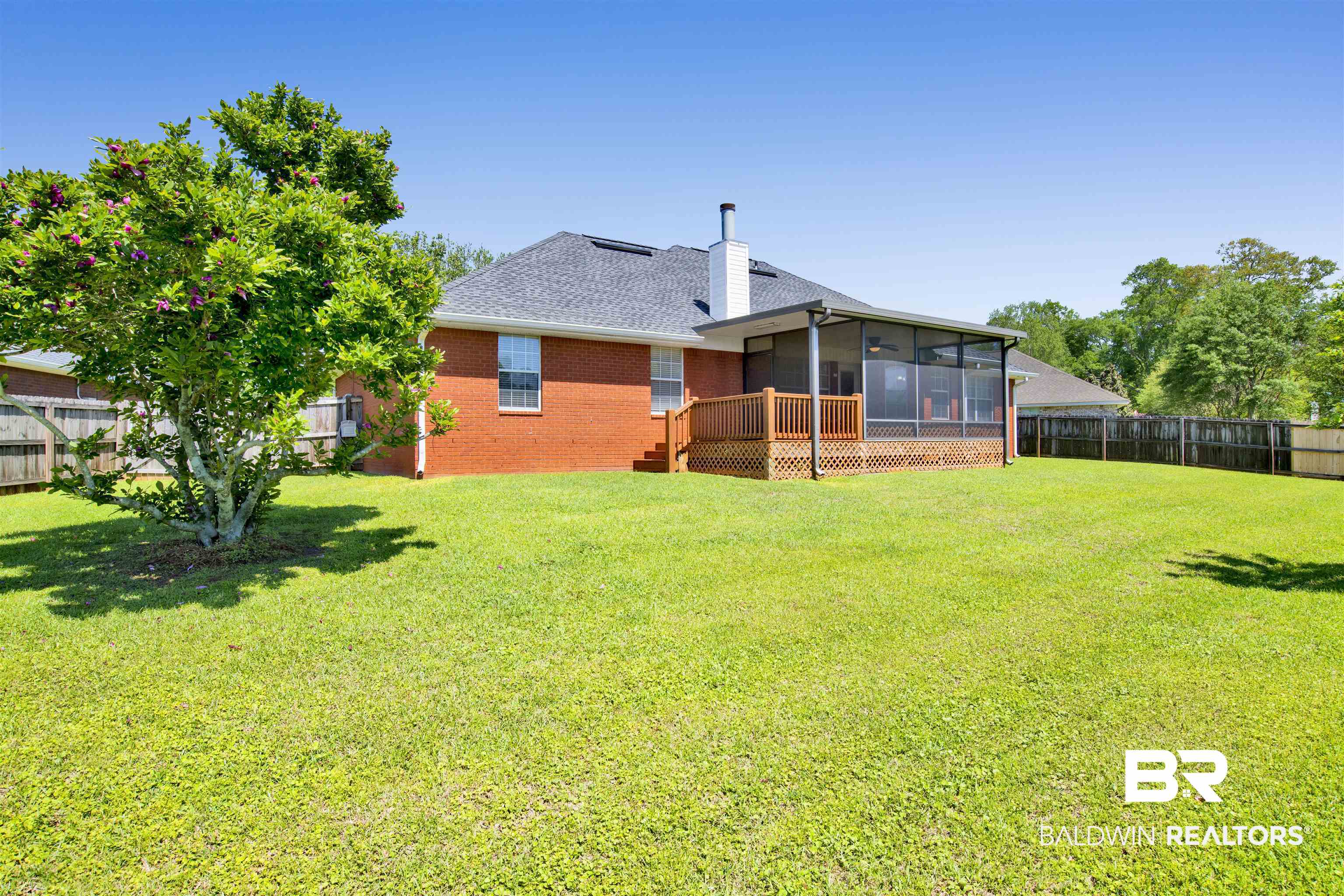 16102 Masada Court Loxley, AL 36551 - Photo 7 of 35 Back of house featuring a sunroom, a fenced backyard, brick siding, and a lawn