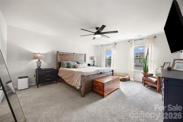 a bedroom with a bed a couch and a flat screen tv