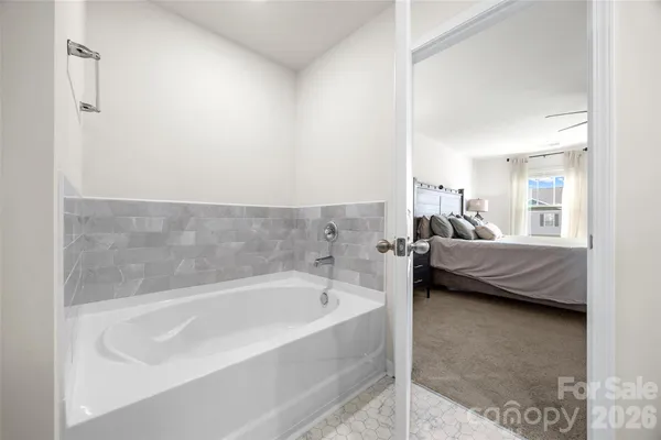 a en suite bathroom with a tub sink and view bedroom
