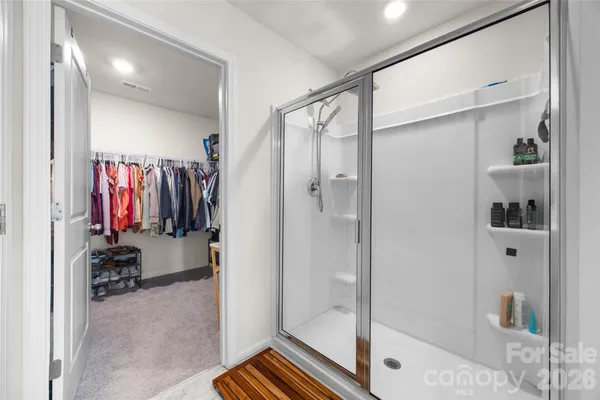 a view of walk in closet with clothes and shoes