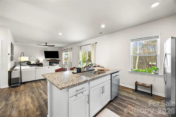 a kitchen with granite countertop kitchen island sink stove and granite counter top