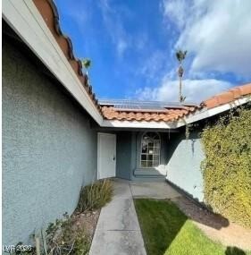 2802 Camelback Lane Henderson, NV 89074 - Photo 2 of 2 Doorway to property featuring stucco siding, roof mounted solar panels, and a tiled roof