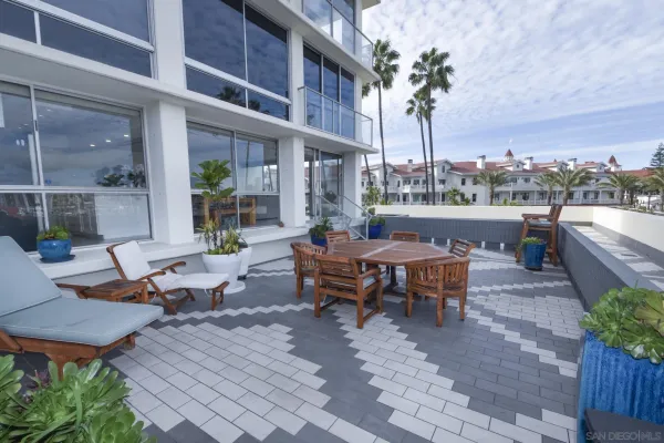 a view of a patio with couches table and chairs and potted plants