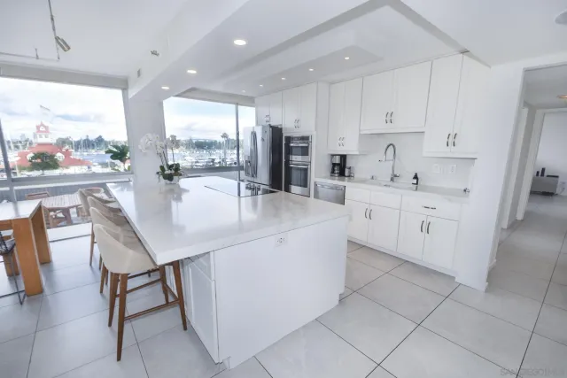 a kitchen with stainless steel appliances kitchen island granite countertop a table chairs sink and cabinets