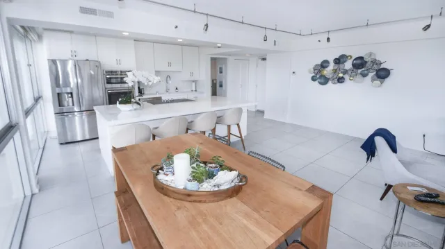 a kitchen with stainless steel appliances a dining table and a refrigerator