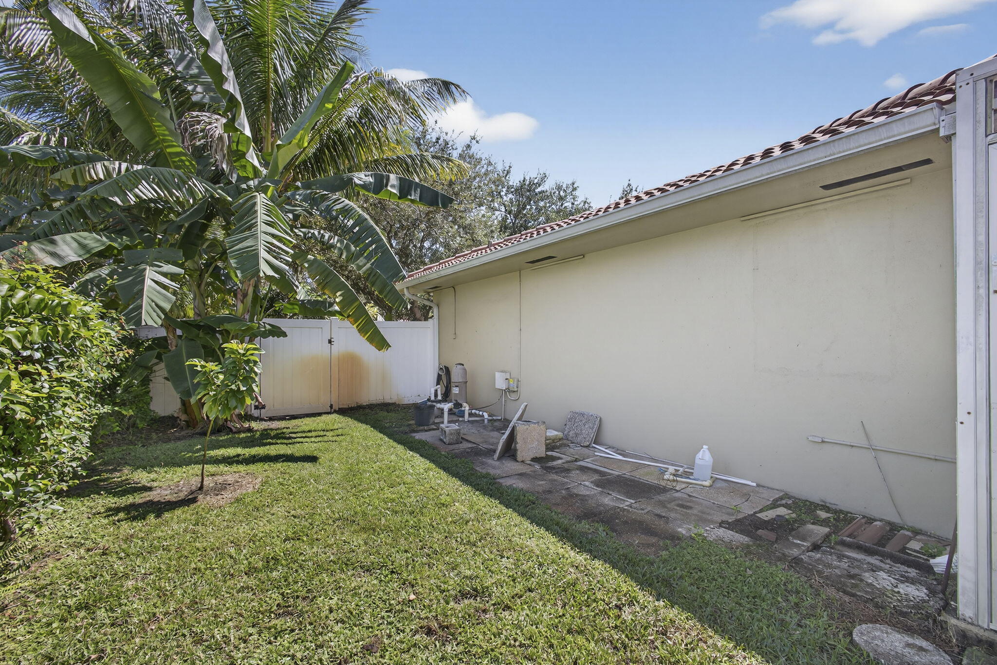 7625 Clarke Road Lake Clarke Shores, FL 33406 - Photo 65 of 97 a backyard of a house with table and chairs