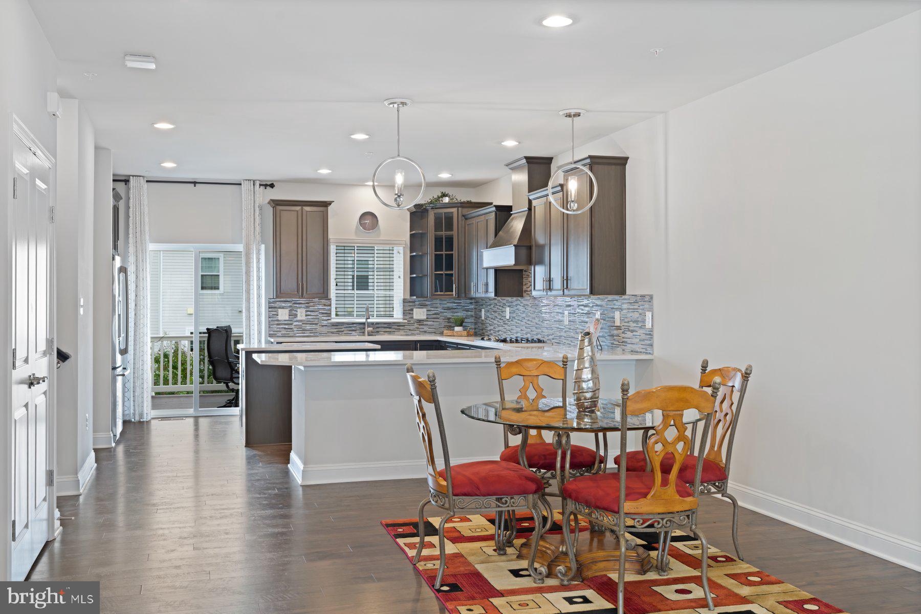 2713 Lady Slipper Road Gambrills, MD 21054 - Photo 13 of 55 a kitchen with stainless steel appliances kitchen island granite countertop a dining table chairs and sink