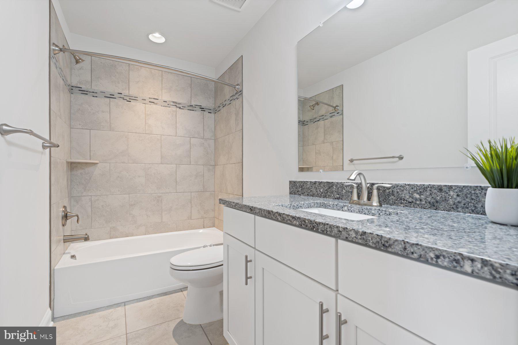 2713 Lady Slipper Road Gambrills, MD 21054 - Photo 29 of 55 a bathroom with a granite countertop sink a toilet and shower