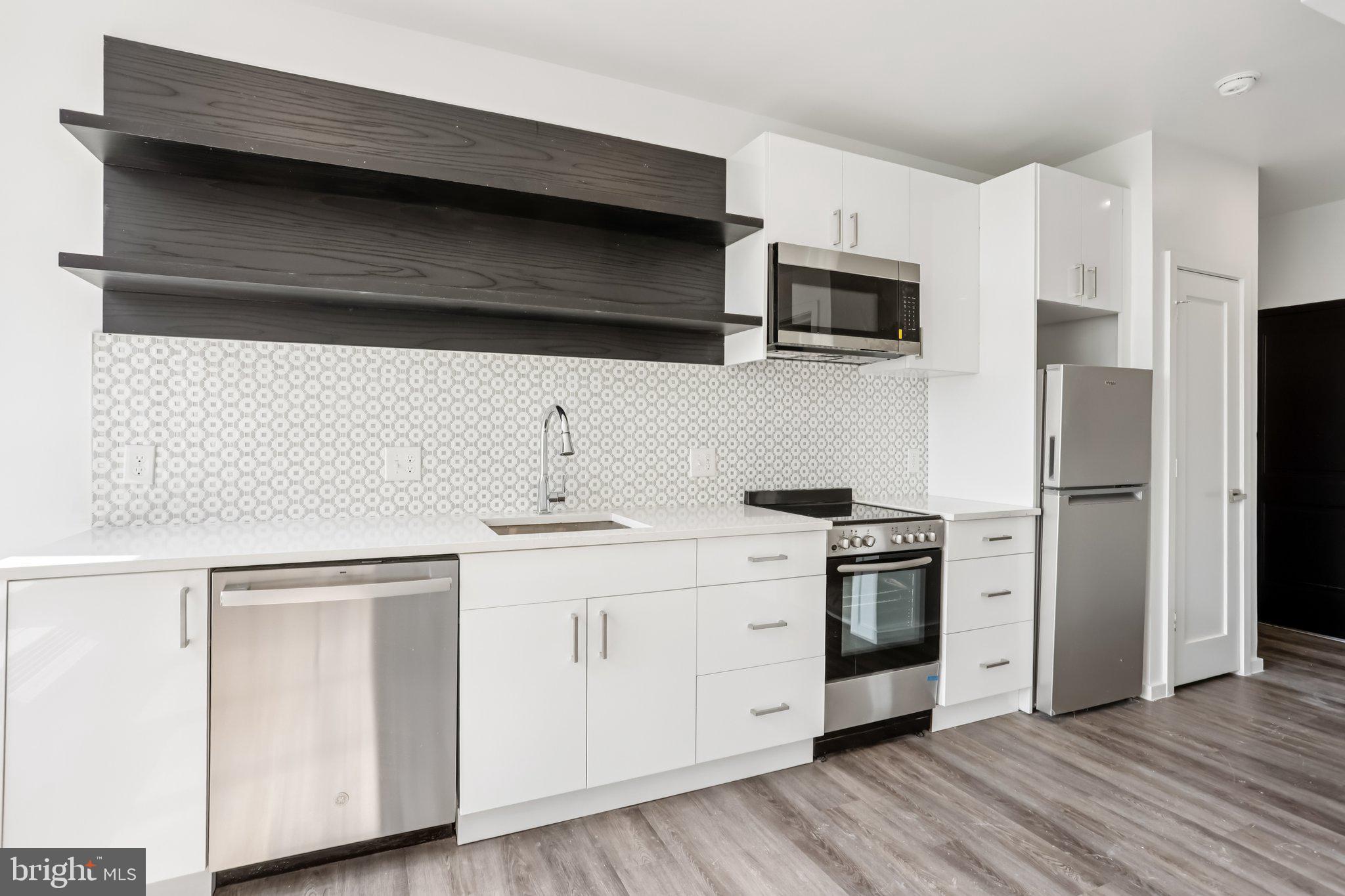 1201 Vine Street, Unit 2 Philadelphia, PA 19107 - Photo 2 of 31 a kitchen with stainless steel appliances a sink dishwasher a refrigerator and wooden floor