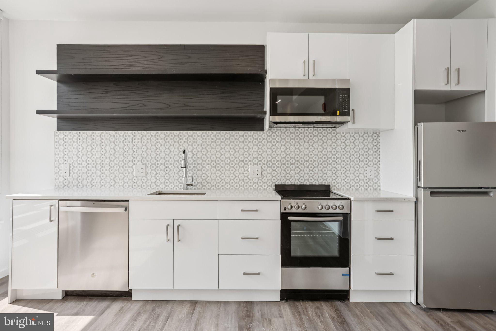 1201 Vine Street, Unit 2 Philadelphia, PA 19107 - Photo 3 of 31 a kitchen with stainless steel appliances a stove a microwave and cabinets