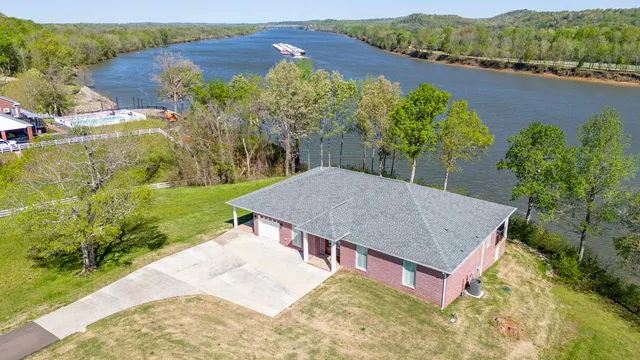 an aerial view of a house with yard and green space