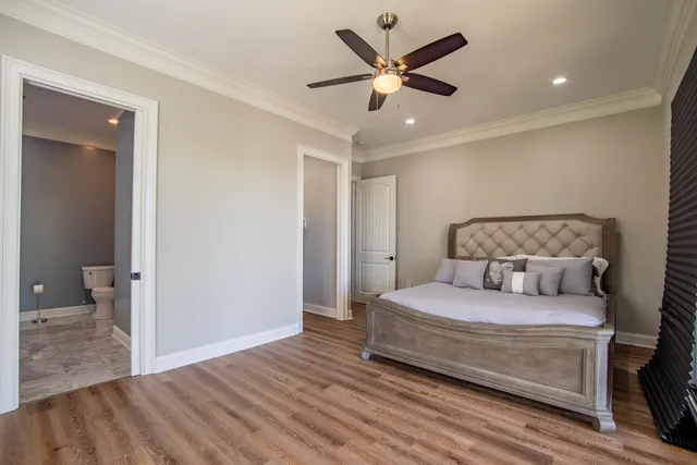 a bedroom with a large bed and a chandelier