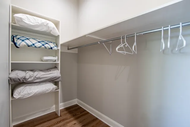 a view of walk in closet with clothes and shoes