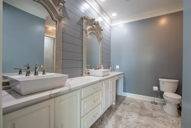 a spacious bathroom with a toilet sink and mirror
