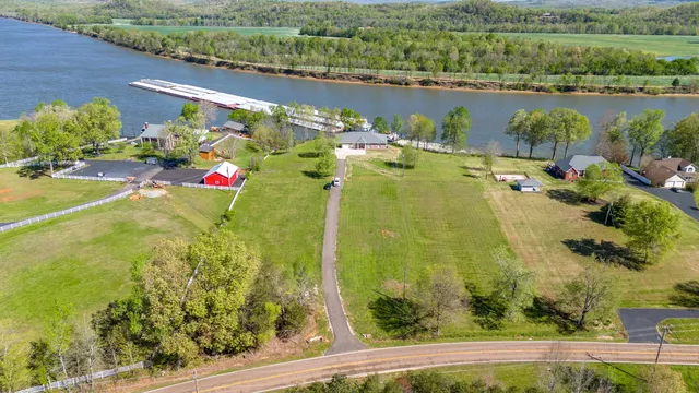 an aerial view of a residential houses with outdoor space and lake view