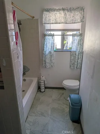 a bathroom with a sink a toilet a window and a bathtub