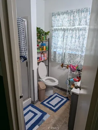 a bathroom with a toilet and shower curtain