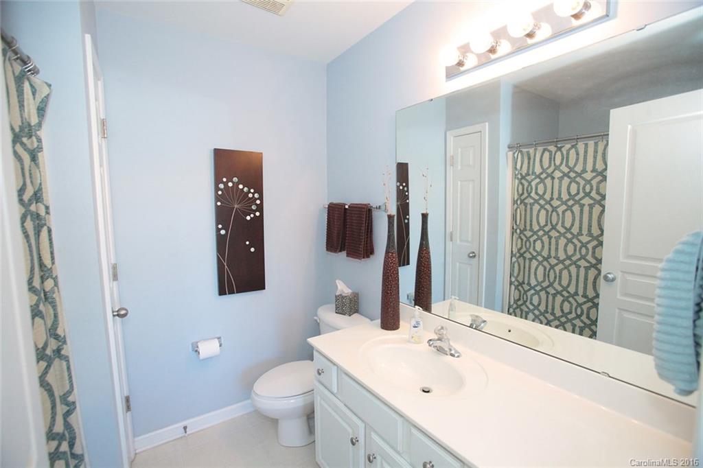 831 Gentlewinds Court, Unit 122 Fort Mill, SC 29708 - Photo 11 of 19 a bathroom with a sink and mirror with toilet