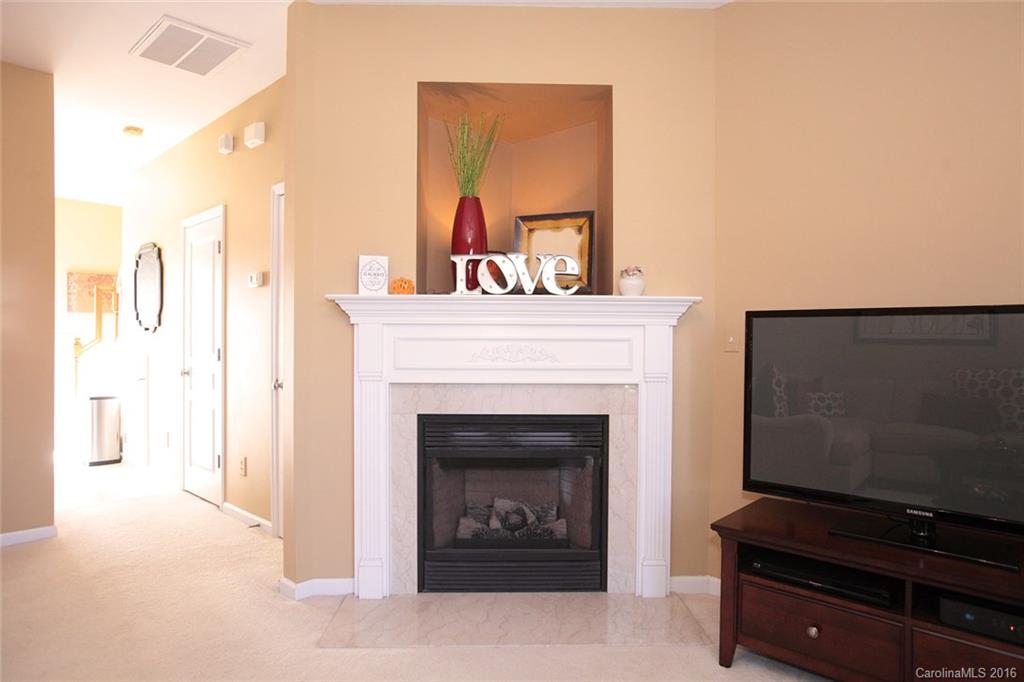 831 Gentlewinds Court, Unit 122 Fort Mill, SC 29708 - Photo 3 of 19 a living room with furniture a fireplace and a flat screen tv