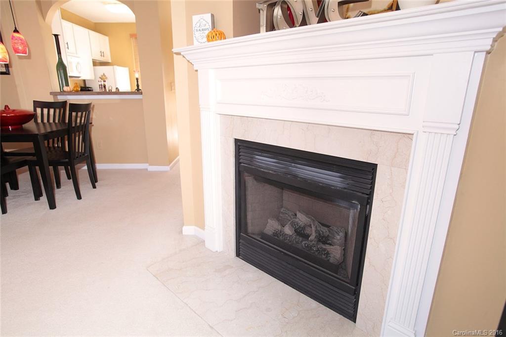 831 Gentlewinds Court, Unit 122 Fort Mill, SC 29708 - Photo 8 of 19 a living room with a fireplace and a table