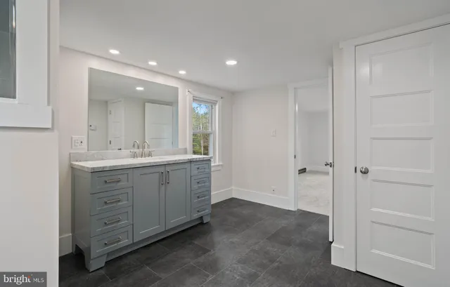 a bathroom with a tub sink and mirror