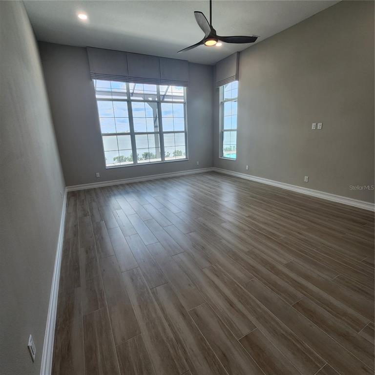 512 Blue Shell Loop Sarasota, FL 34240 - Photo 26 of 44 an empty room with wooden floor and windows