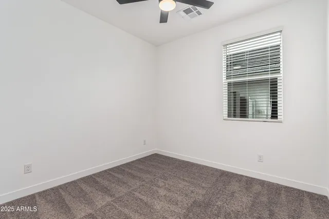 an empty room with a window and a kitchen