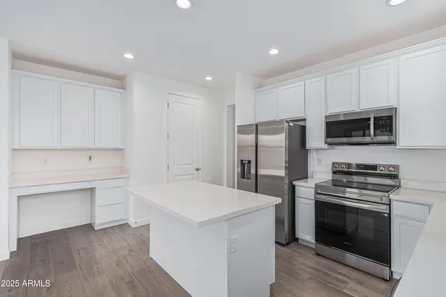 a kitchen with a refrigerator stove and white cabinets