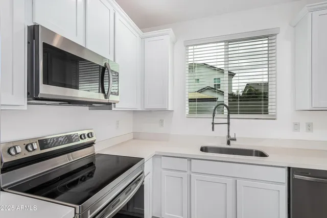 a kitchen with appliances a sink and cabinets