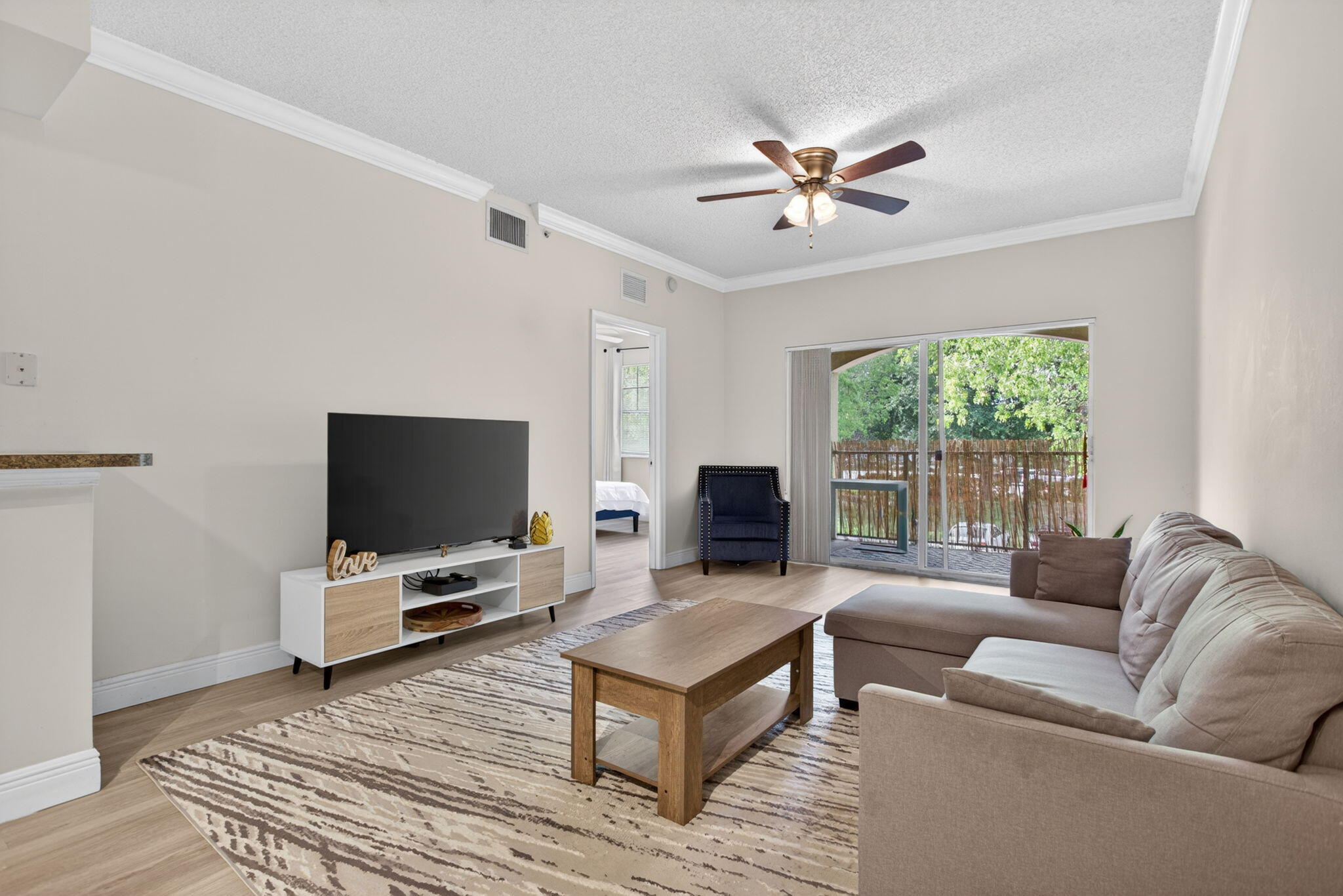 5880 West Sample Road, Unit 206 Coral Springs, FL 33067 - Photo 10 of 37 a living room with furniture and a flat screen tv