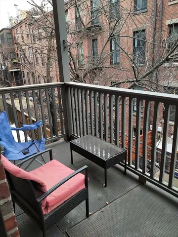 a backyard of a house with wooden floor and outdoor seating