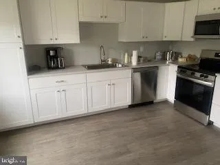 a kitchen with white cabinets and stainless steel appliances