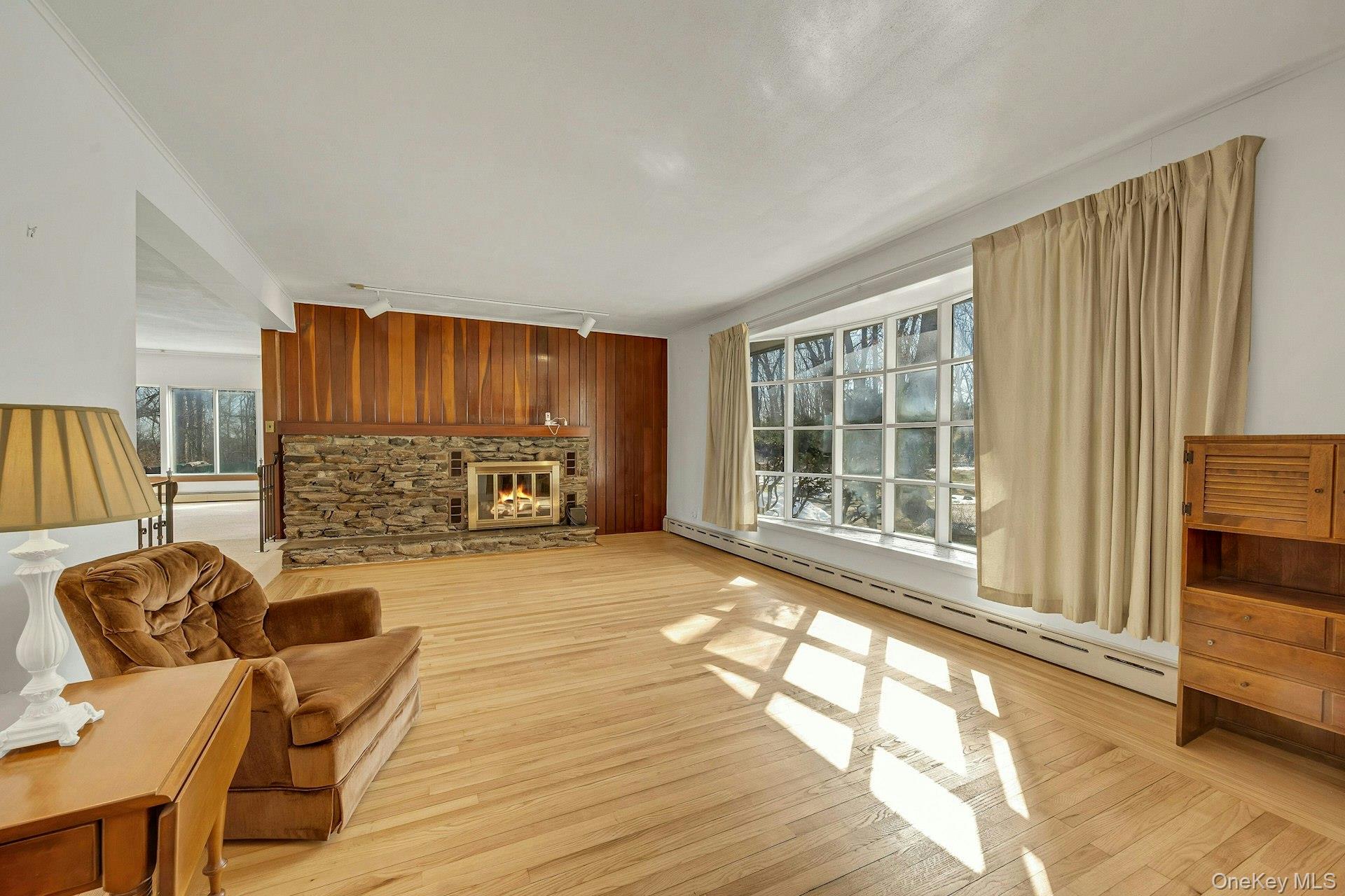 16 Young Road Katonah, NY 10536 - Photo 4 of 26 The rustic wood burning fireplace and attractive picture window create a warm welcome to the home.