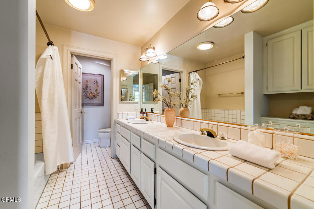 427 Long Canyon Road Bradbury, CA 91008 - Photo 31 of 62 a spacious bathroom with a double vanity sink a mirror and a shower