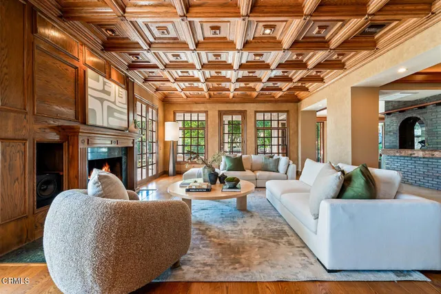 a view of a livingroom with furniture a fireplace and wooden floor
