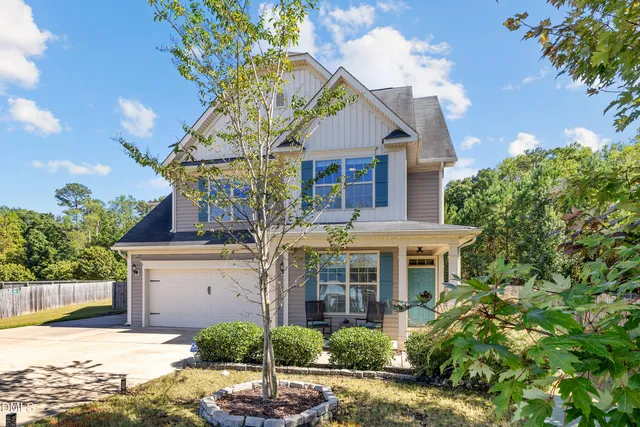 a front view of a house with a yard and potted plants