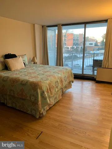 a spacious bedroom with a bed and a large window