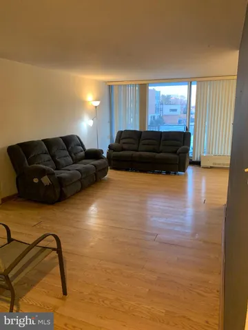 a living room with a couch and dresser with wooden floor