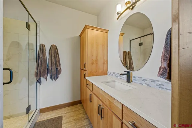 a spacious bathroom with a double vanity sink a mirror and shower