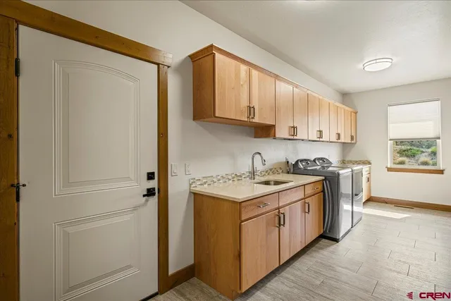 a kitchen with stainless steel appliances granite countertop a stove a sink and a refrigerator with wooden cabinets
