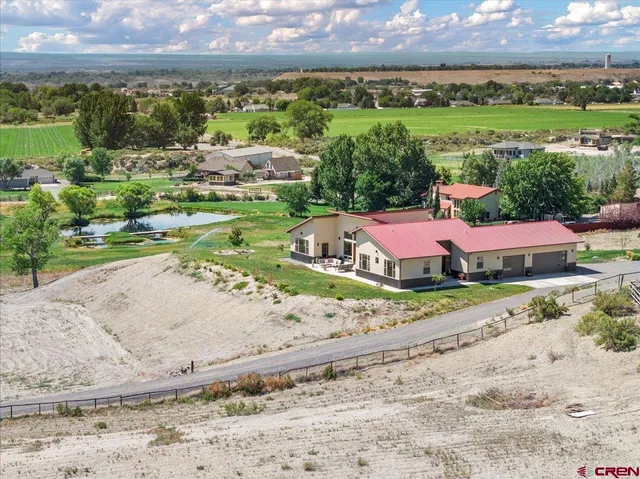 an aerial view of a house with a garden and mountain view in back