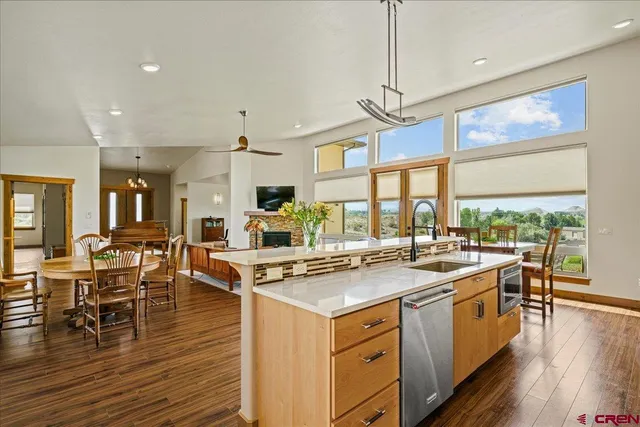 a kitchen with a stove a sink a kitchen island with wooden cabinets and wooden floor