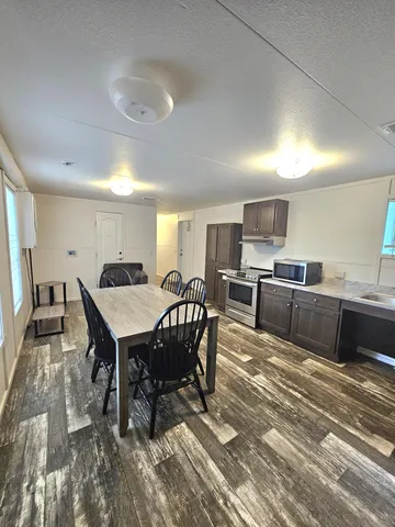 a kitchen with a table chairs microwave and cabinets