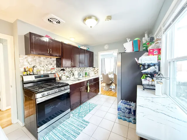 a kitchen with granite countertop a stove cabinets and refrigerator