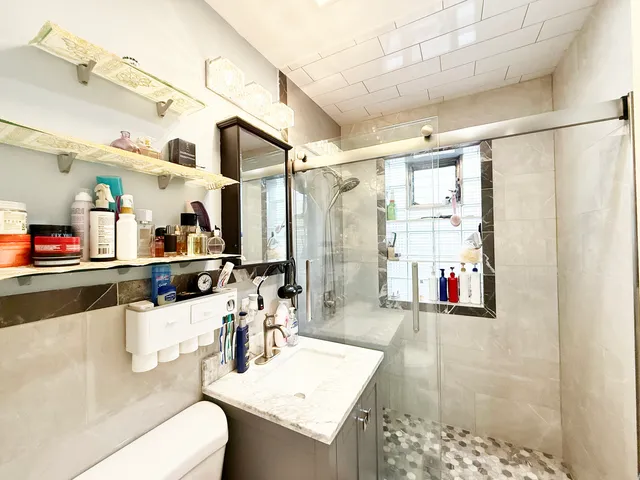 a bathroom with a sink vanity granite and shower