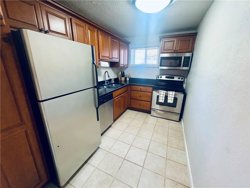 250 Little Street, Unit C101 Athens, GA 30605 - Photo 4 of 16 a kitchen with stainless steel appliances a refrigerator sink and cabinets