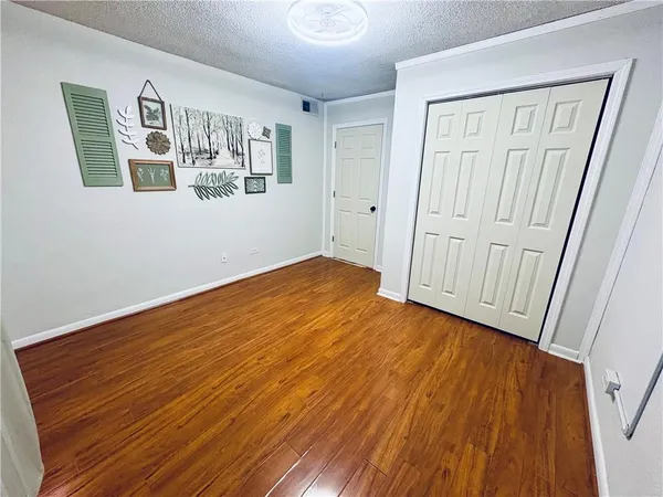 a view of an empty room with wooden floor