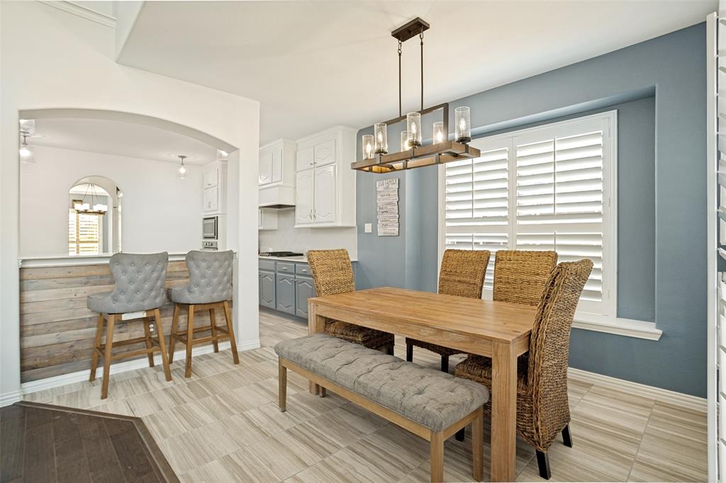 1461 Ramsbury Lane Prosper, TX 75078 - Photo 10 of 30 Dining area featuring a contemporary chandelier, wood-finish flooring, and white plantation shutters