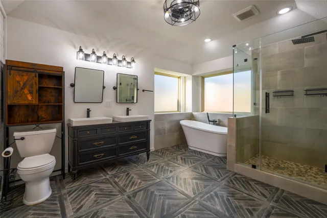 a spacious bathroom with a double vanity sink toilet and shower